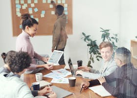 A diverse group of professionals discussing ideas in a modern office setting. Perfect for business and teamwork concepts.