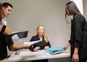 Group of professionals in intense office meeting analyzing documents and plans.